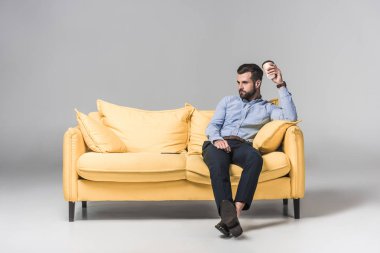 formal giyim kahve holding ve gri sarı koltukta oturan sıkılmış adam
