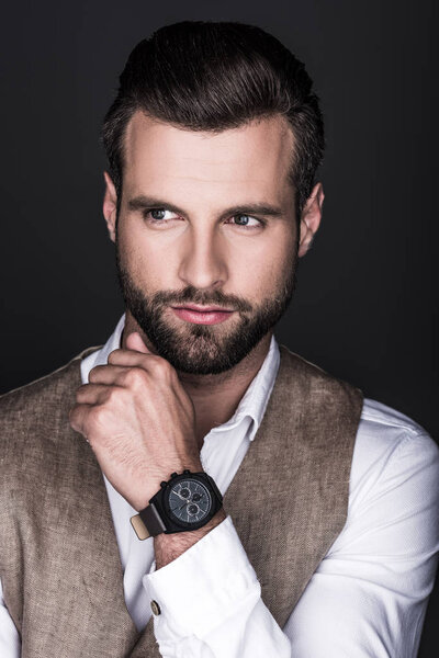 portrait of elegant bearded man with wristwatch, isolated on grey