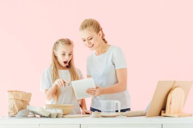 pişirme pink izole iken anne ve sürpriz kızı beyaz gülümseyen t-shirt kullanarak tablet