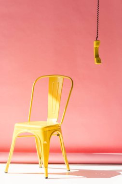 yellow chair and phone tube on pink clipart