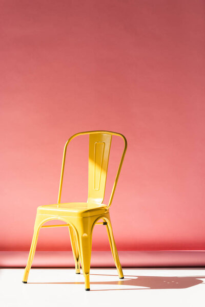 stylish yellow chair and on pink with copy space