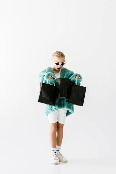 Shocked Kid Stylish Fur Coat Looking Black Shopping Bags Isolated — Stock Photo, Image