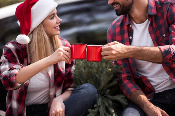 Sonriente Pareja Tintineo Con Tazas Rojas Mientras Está Sentado Camioneta — Foto de stock gratuita