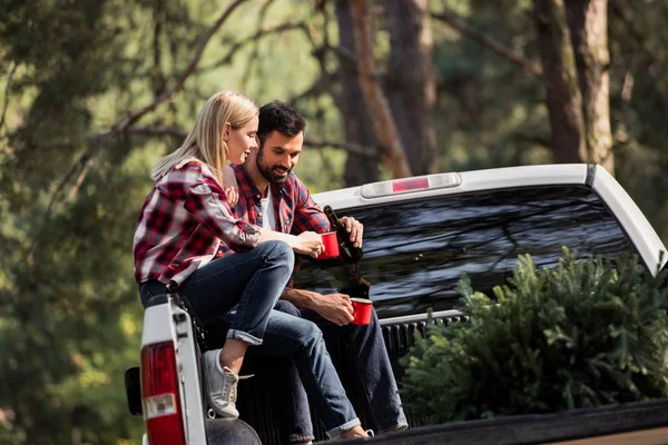 Young Couple Pouring Wine Cups While Sitting Pickup Truck Christmas — Stock Photo, Image