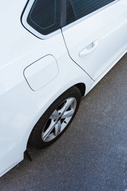 cropped image of wheel and door of new white car on street clipart