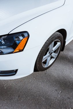 Far görüntüsünü ve beyaz yeni araba tekerlek yol üzerinde kırpılmış