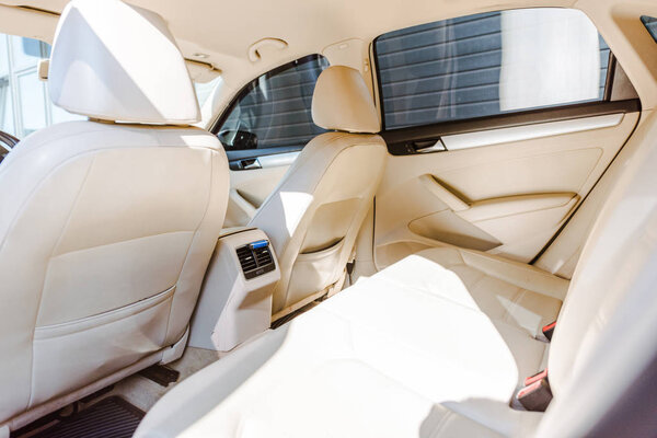 interior of beige leather new car with sunlight