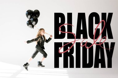 fashionable child in trendy suit jumping with black balloons on grey, black friday banner concept clipart