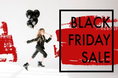 fashionable child in trendy suit jumping with black balloons on grey, black friday sale banner concept clipart