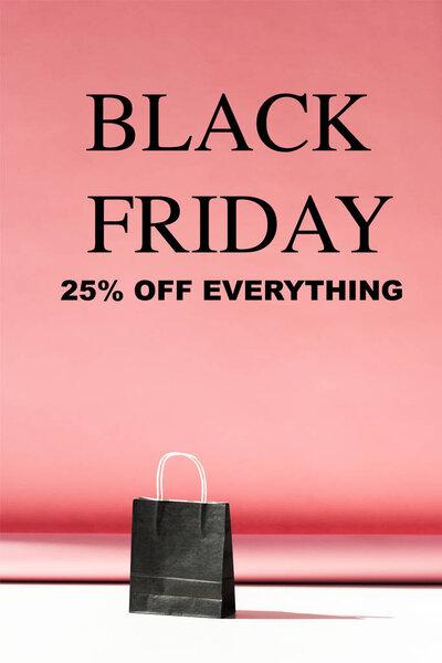 one black shopping bag on pink with copy space, black friday sale banner