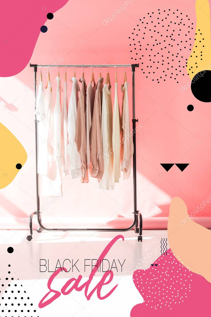 light stylish clothes on hangers in pink boutique, black friday sale banner concept