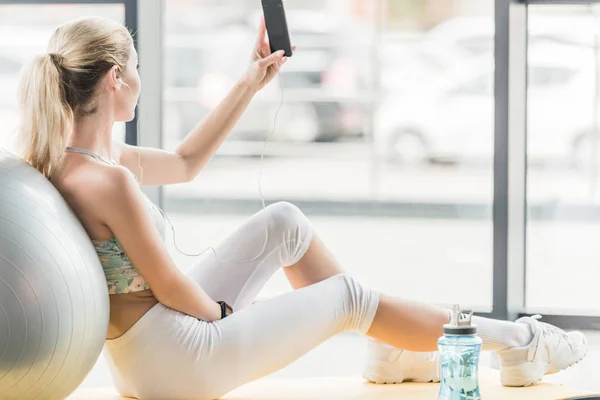 Enfoque Selectivo Deportista Con Auriculares Tomando Selfie Teléfono Inteligente Gimnasio —  Fotos de Stock