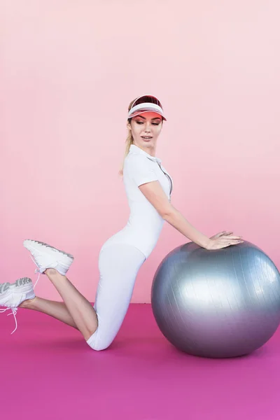 Hübsche Junge Sportlerin Mit Schirmmütze Posiert Neben Grauem Fitnessball Auf Stockbild