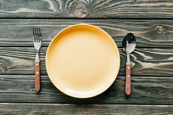 Teller mit Besteck auf Holztisch — Stockfoto