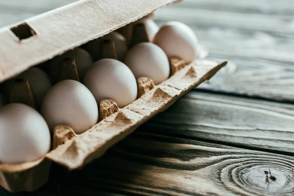 Chicken eggs in box on wooden table — Stock Photo