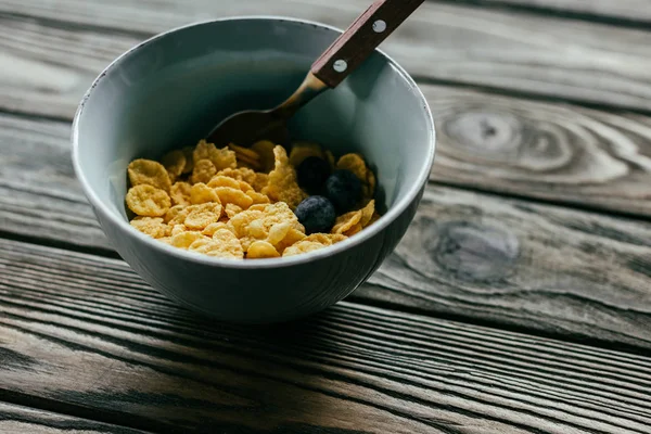Breakfast flakes in bowl on wooden table — Stock Photo