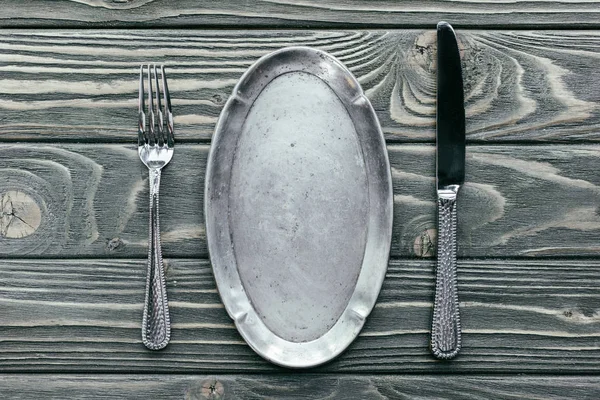 Bandeja de plata con cubiertos sobre mesa de madera - foto de stock