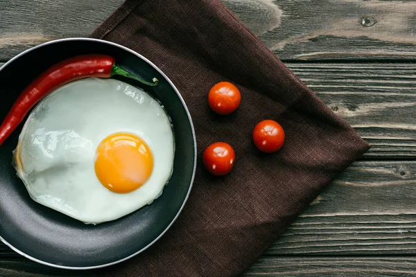 Сніданок зі смаженим яйцем та помідорами на текстильній серветці — стокове фото