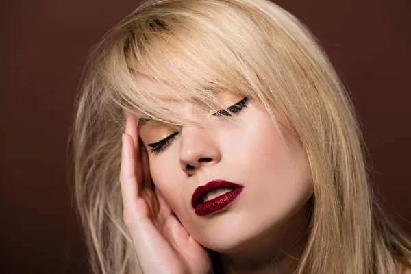 Portrait de jeune femme blonde sensuelle aux yeux fermés posant sur le brun — Photo de stock