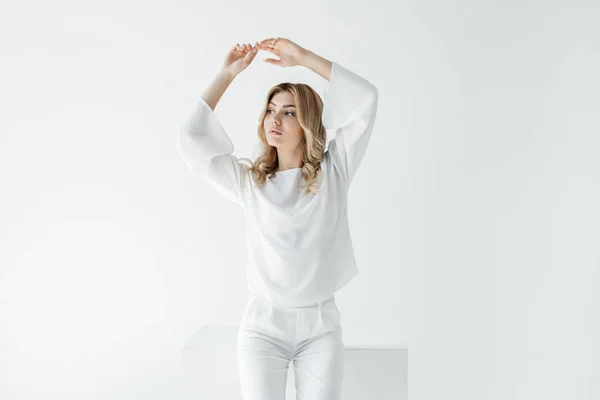 Bella donna bionda pensierosa in abiti bianchi posa isolata su bianco — Foto stock
