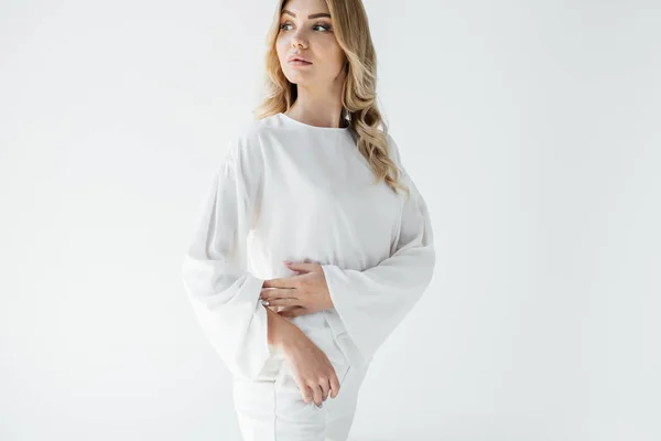Porträt einer schönen nachdenklichen blonden Frau in weißer Kleidung, die isoliert von weißer Kleidung wegschaut — Stockfoto