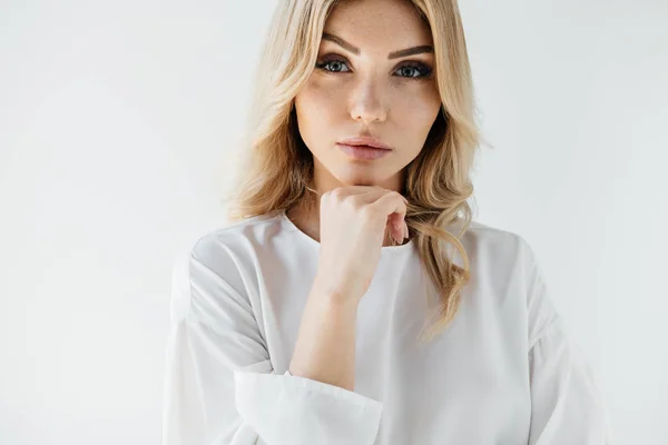 Retrato de hermosa mujer rubia en ropa blanca posando sobre fondo blanco - foto de stock