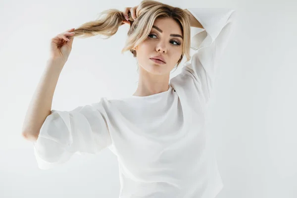 Retrato de mujer rubia pensativa en ropa blanca mirando hacia otro lado aislado en blanco - foto de stock