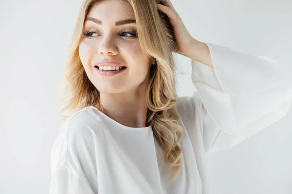 Retrato de hermosa mujer sonriente en ropa blanca mirando hacia otro lado en el fondo blanco - foto de stock