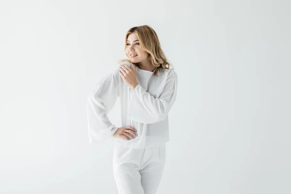 Retrato de hermosa mujer sonriente en ropa blanca mirando hacia otro lado aislado en blanco - foto de stock