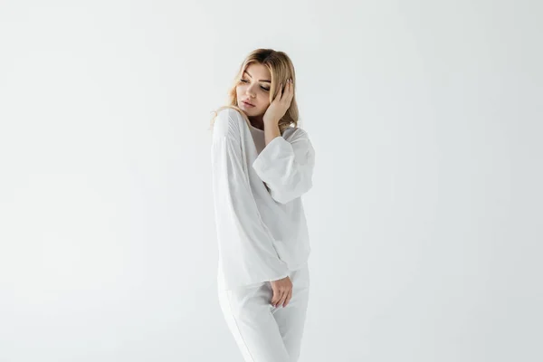Porträt einer nachdenklichen Frau in weißer Kleidung, die isoliert auf weißem Grund posiert — Stockfoto