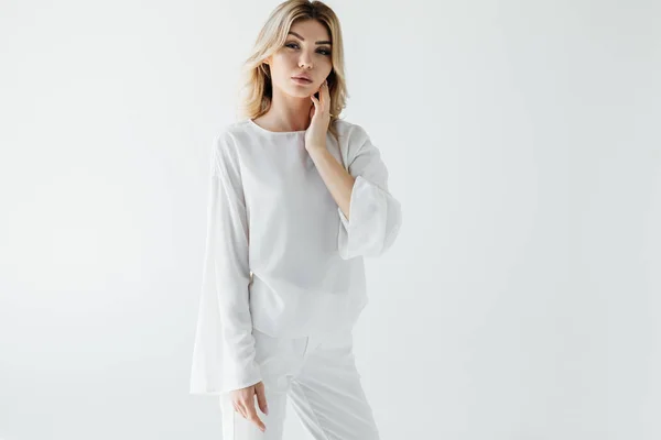 Ritratto di donna bionda pensierosa in abiti bianchi in posa isolata su bianco — Foto stock