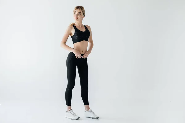 Beautiful sportswoman in black sportswear standing isolated on grey — Stock Photo