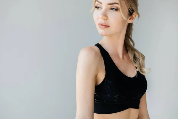 Portrait of young athletic woman in black sportswear posing isolated on grey — Stock Photo