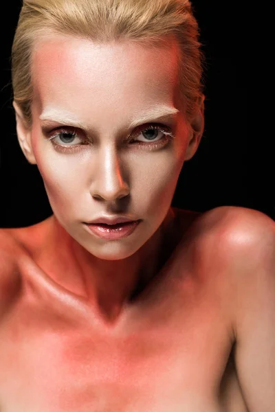 Attraktive Frau mit roter Körperkunst, die in die Kamera blickt, isoliert auf schwarz — Stockfoto