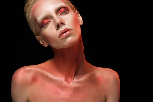 Красива гола модна дівчина позує з червоним тілом і закритими очима, ізольована на чорному — стокове фото