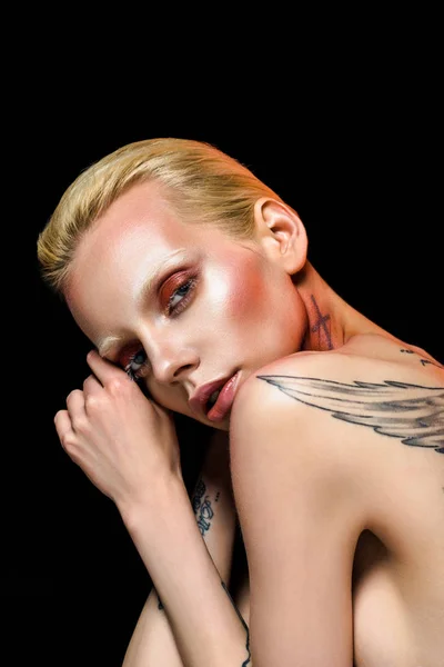 Hermosa chica desnuda con alas tatuadas en la espalda, aislado en negro - foto de stock