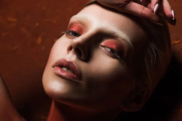 Sinnliches Mädchen mit modischem roten Make-up, das in die Kamera blickt — Stockfoto