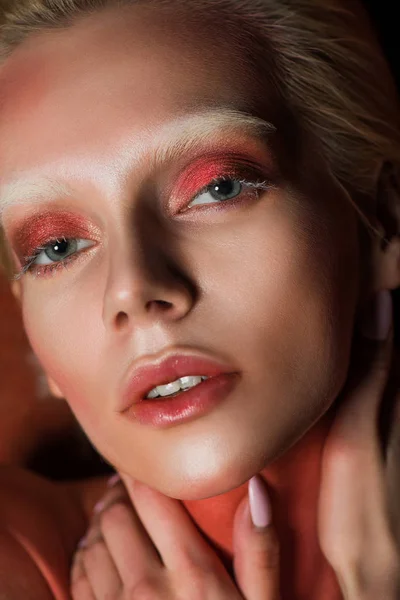 Sensual mujer con maquillaje rojo mirando a la cámara - foto de stock