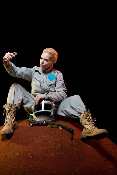 Космонавт в скафандре с селфи на смартфоне на планете — стоковое фото