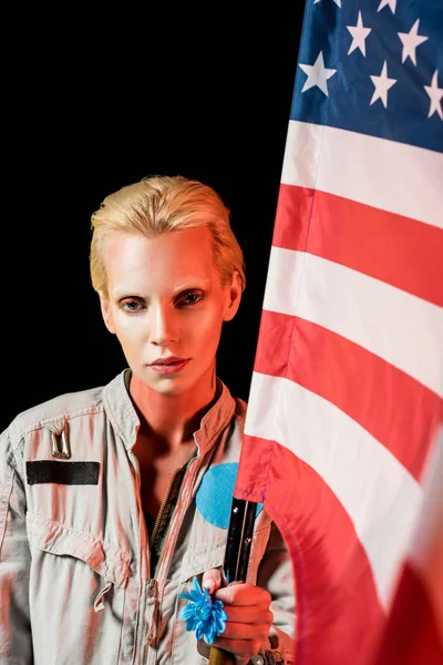 Attractive female astronaut in spacesuit holding american flag, isolated on black — Stock Photo