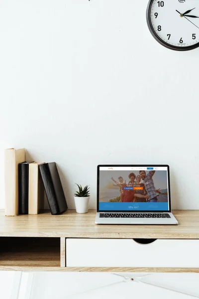 Ordinateur portable avec site de couchsurfing à l'écran sur la table de travail au bureau — Photo de stock