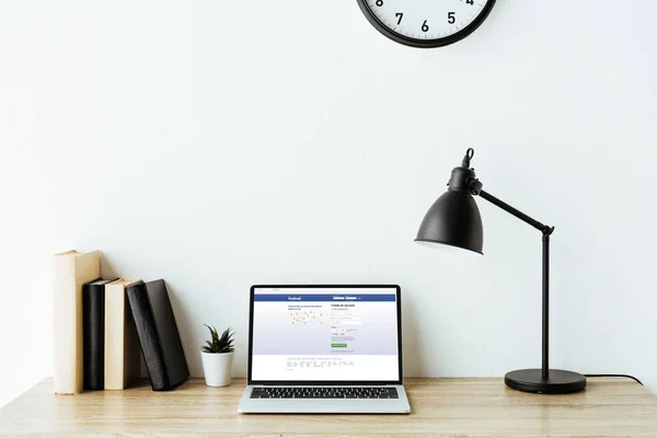 Laptop mit Facebook-Website auf dem Bildschirm am Schreibtisch im Büro — Stockfoto