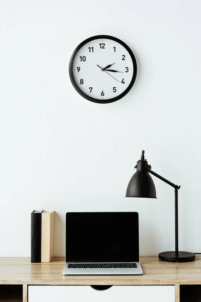 Laptop with books and table lamp on work desk at office — Stock Photo