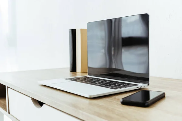 Ноутбук і смартфон з порожніми екранами на дерев'яній поверхні — стокове фото