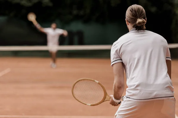 Back view of retro styled tennis players during game at tennis court — Stock Photo