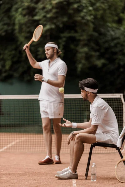 Jugadores de tenis de estilo retro preparándose para el juego en la cancha de tenis - foto de stock