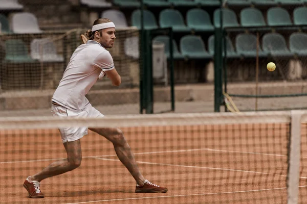 Fokussierter gutaussehender Mann im Retro-Stil spielt Tennis auf dem Court — Stockfoto