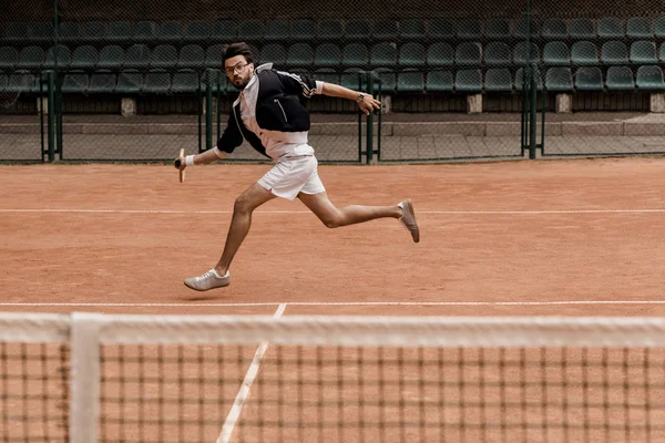 Homme beau style rétro jouant au tennis au court de tennis — Photo de stock