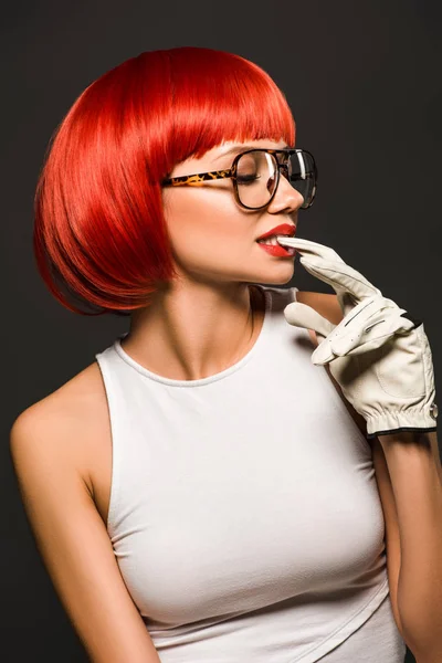 Séduisante jeune femme avec bob rouge coupé en gant de golf et des lunettes élégantes isolées sur gris — Photo de stock