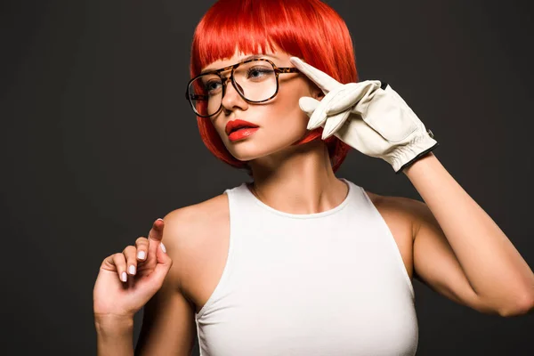Schöne junge Frau mit rotem Bob-Schnitt im Golfhandschuh und stylischer Brille isoliert auf grau — Stockfoto